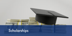 Image of stacks of cash with a graduation cap on top.