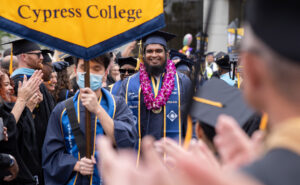 a student participates in Cypress College's 55th commencement as faculty applaud the Class of 2022 during the processional