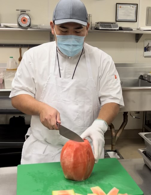 Chef Jonathan Park cuts fruit for plant-based Wednesday lunches at Santa Ana Unified School District